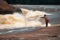 Un ind&iacute;gena lanza su atarraya a las turbulentas aguas del raudal Zamuro en el r&iacute;o In&iacute;rida, para capturar f&aacute;cilmente los peces que tienen que nadar contra la corriente.